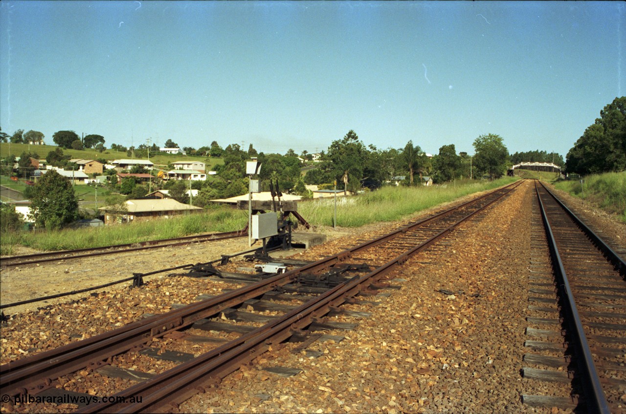187-14
Monkland, Gympie Queensland. View looking south east in the Up direction, points off loop for yard, footbridge for State School in the distance. [url=https://goo.gl/maps/sKfP96uLv112]GeoData[/url].
