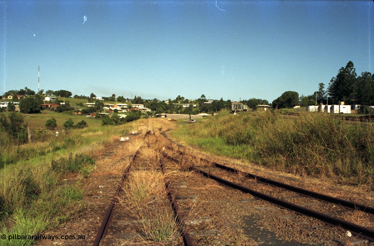 187-15
Monkland, Gympie Queensland. View looking east into the lower yard, overgrown. Molasses tanks in upper yard at unloading siding. [url=https://goo.gl/maps/bcrsBh862ys]GeoData[/url].
