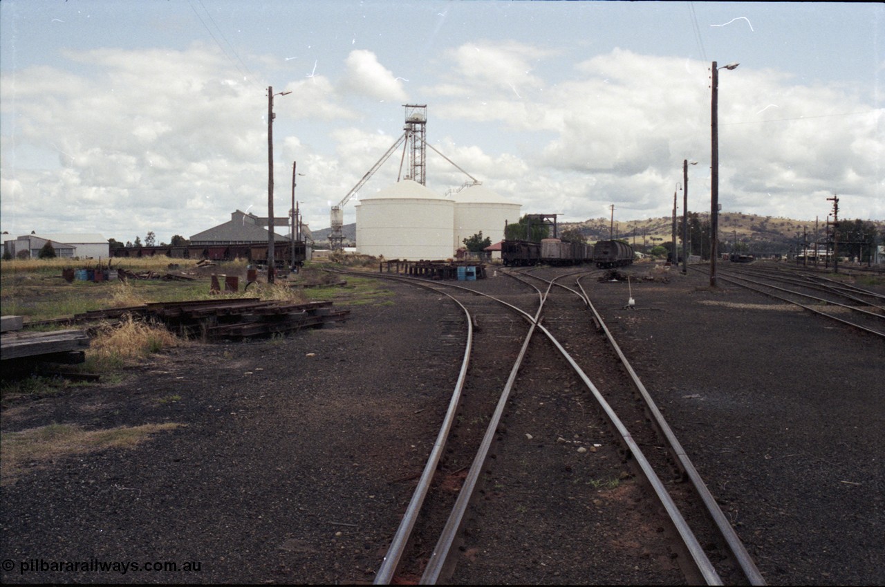 190-10
Cootamundra, NSW Main South, looking south with the grain loading area and Ascom silo complex and the yard with rakes of stored waggons.
