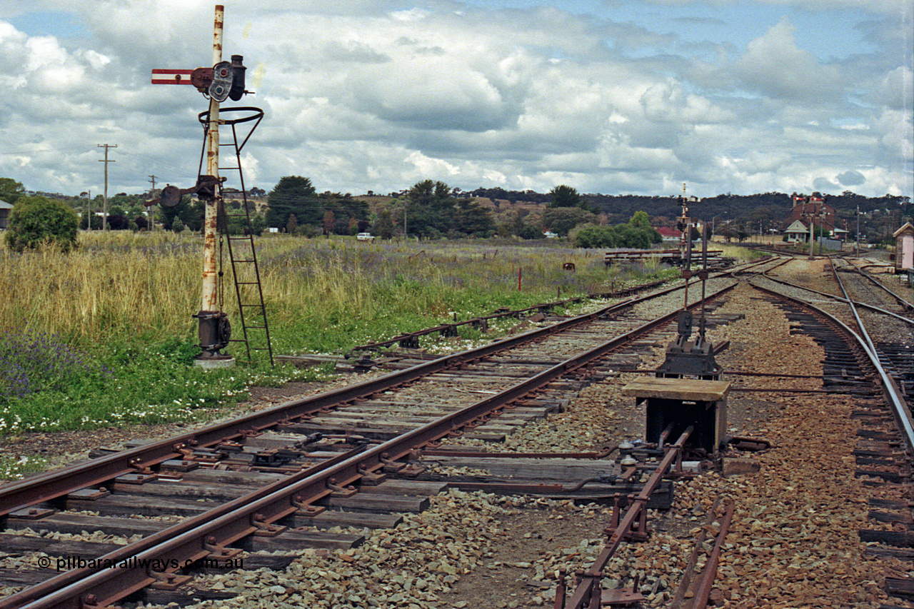 192-29
Cootamundra West, NSW, view of Frame B and metal post mechanical lower quadrant semaphore signal operated by lever 37 is for up moves out of the Refuge or Goods Sidings to the Loop Line. The signal post is reduced in height due to the airfield adjacent to the line.
