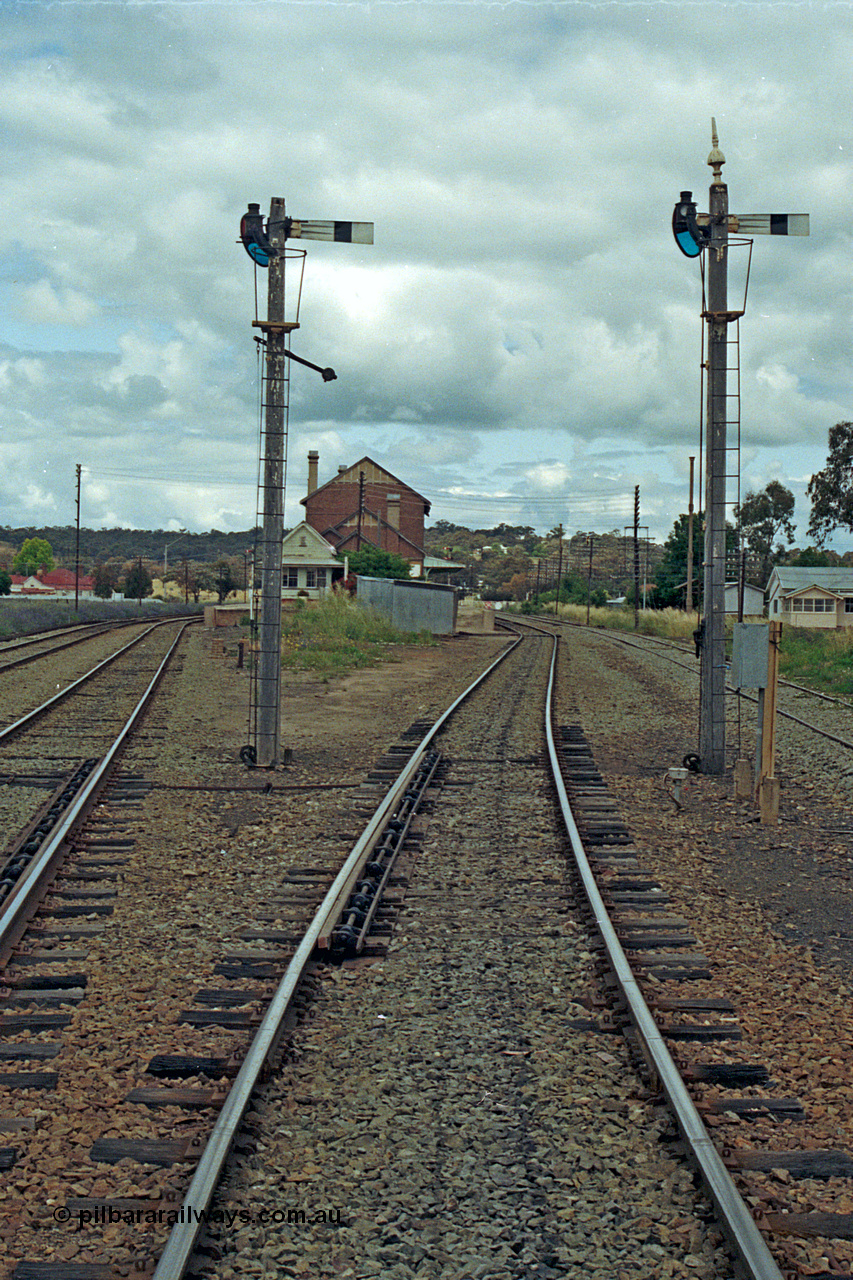 192-32
Cootamundra West, NSW, looking east in the up direction with the Loop Line on the far left, Main Line lower quadrant semaphore for down movements to Main Line operated by lever 7 and South Fork down movements to Main Line by lever 3, the point clearance bars are visible, the signal box and station along with the Ganger's trolley hut are in the distance and the siding at right is Tumut Siding. The house in the distance looks a lot like a NSWGR departmental residence.
