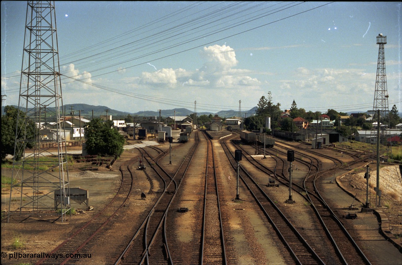 193-16
Gympie station yard overview looking south in the Up direction from the Stewart Terrace overbridge, zoomed in, station and platform in the middle, loco turntable to the right. [url=https://goo.gl/maps/zamovD9hxbu]GeoData[/url].
