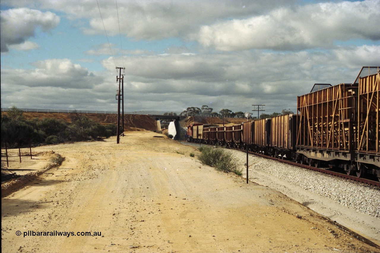 200-05
Moorine Rock, Westrail L class 271 Clyde Engineering EMD model GT26C serial 69-620 runs through the loop with the ballast cleaning train, known as the Circus Train while a Perth bound freighter sits in the mainline, 22nd June 1997.

