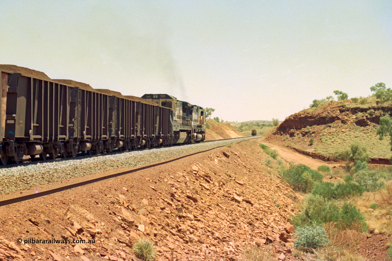 202-29
Yandi One, 307 km grade crossing sees a loaded train departing behind a CM40-8M and an CM40-8 unit with the rail grinder in the back track in the distance.
