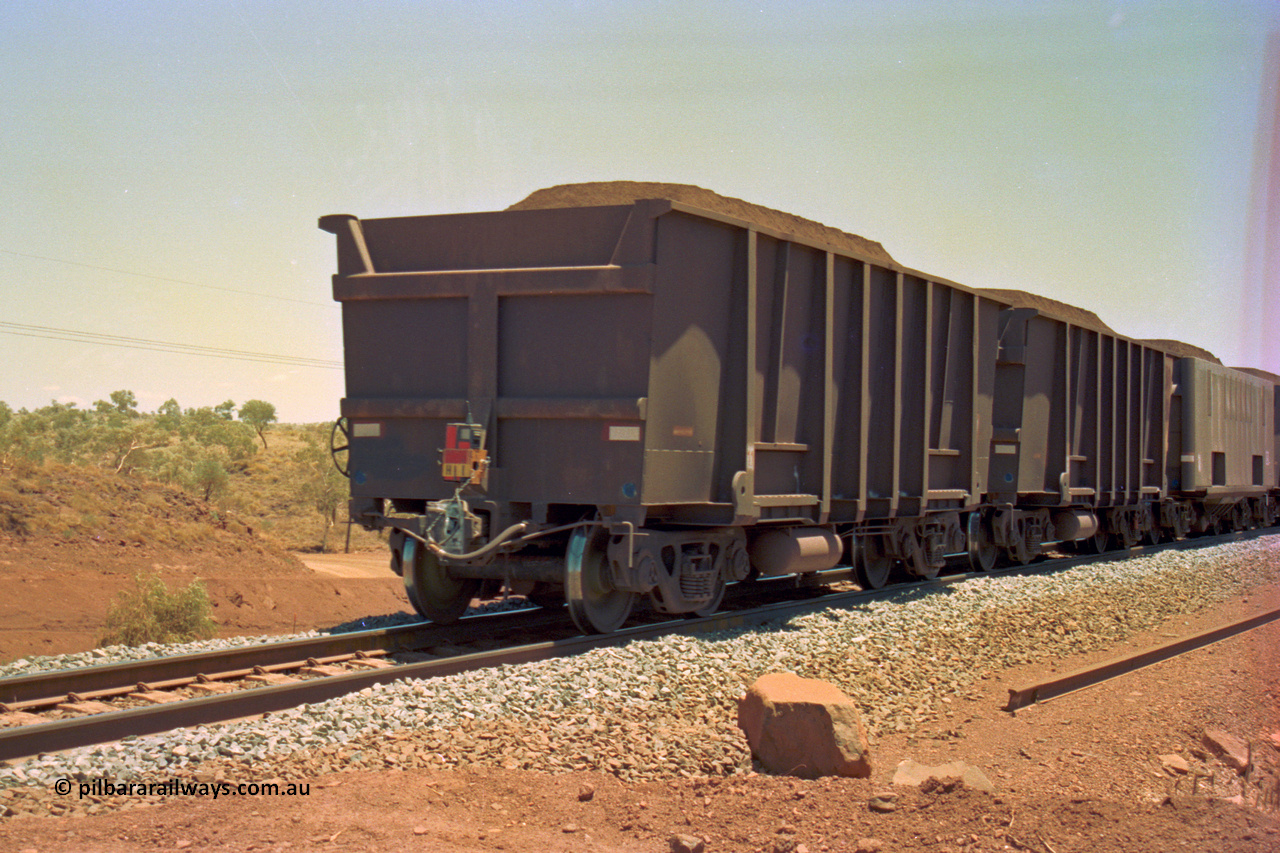 202-33
Yandi One, 307 km grade crossing, the last waggons on a loaded train, the last two are both Comeng style waggons, while the third, also being built by Comeng was originally built as a fixed wheel waggon with four axles, later converted to bogies.
