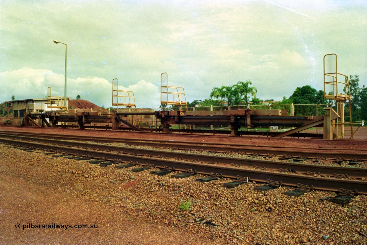 210-01
Weipa, Lorim Point, Comalco rail dump station, view of the hydraulic jacking or indexing arms located on the workshops or empty car side of the unloader, used to position the train for unloading.
