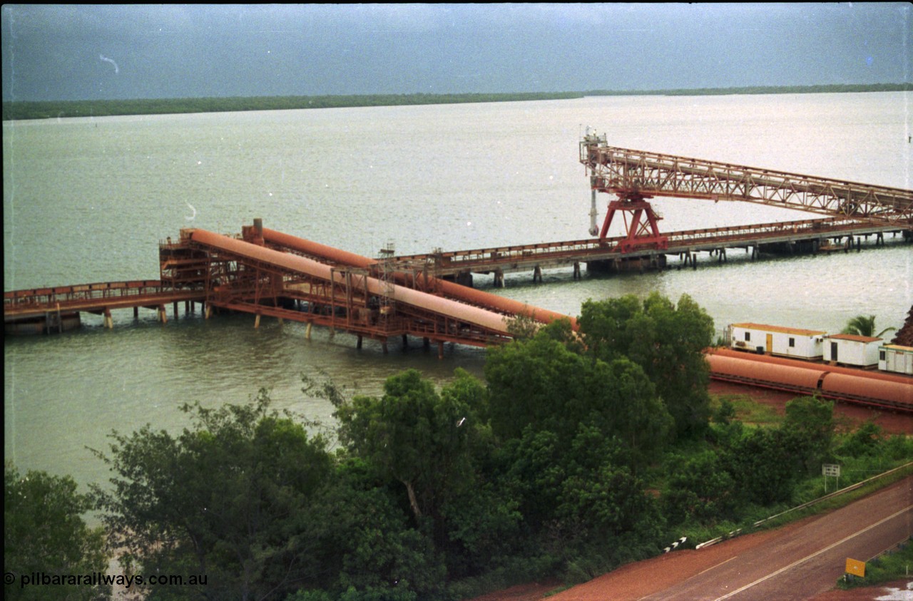 211-04
Weipa, Lorim Point, view of the two loading conveyors running between the stockpiles and wharf, the kaolin loader in on the right hand side of the wharf.
