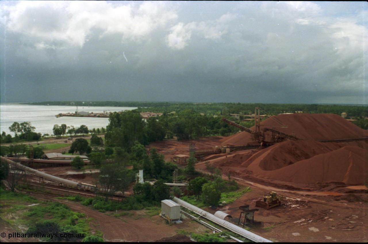 211-07
Weipa, Lorim Point, view from kaolin storage silos looking at Even's Landing in the background and the shiploading stockpile area of bauxite on the right while a storm threatens in the distance.
