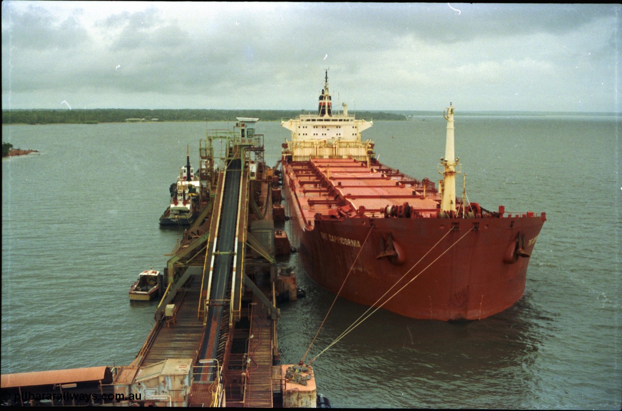 211-32
Weipa, Lorim Point overview of no. 2 bauxite berth looking south east, line boat, tug boats, no. 2 ship loader and the TNT Capricornia, a coal fired 75,500-dwt bulk carrier built by Italcantieri for TNT Bulkships trade run between Gladstone and Weipa.
