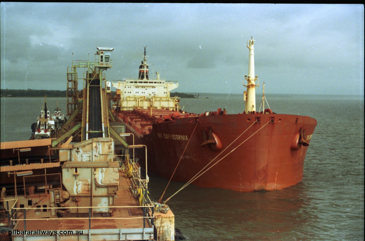 211-35
Weipa, Lorim Point overview of no. 2 bauxite berth looking south east, tug boats, no. 2 ship loader and the TNT Capricornia, a coal fired 75,500-dwt bulk carrier built by Italcantieri for TNT Bulkships trade run between Gladstone and Weipa.
