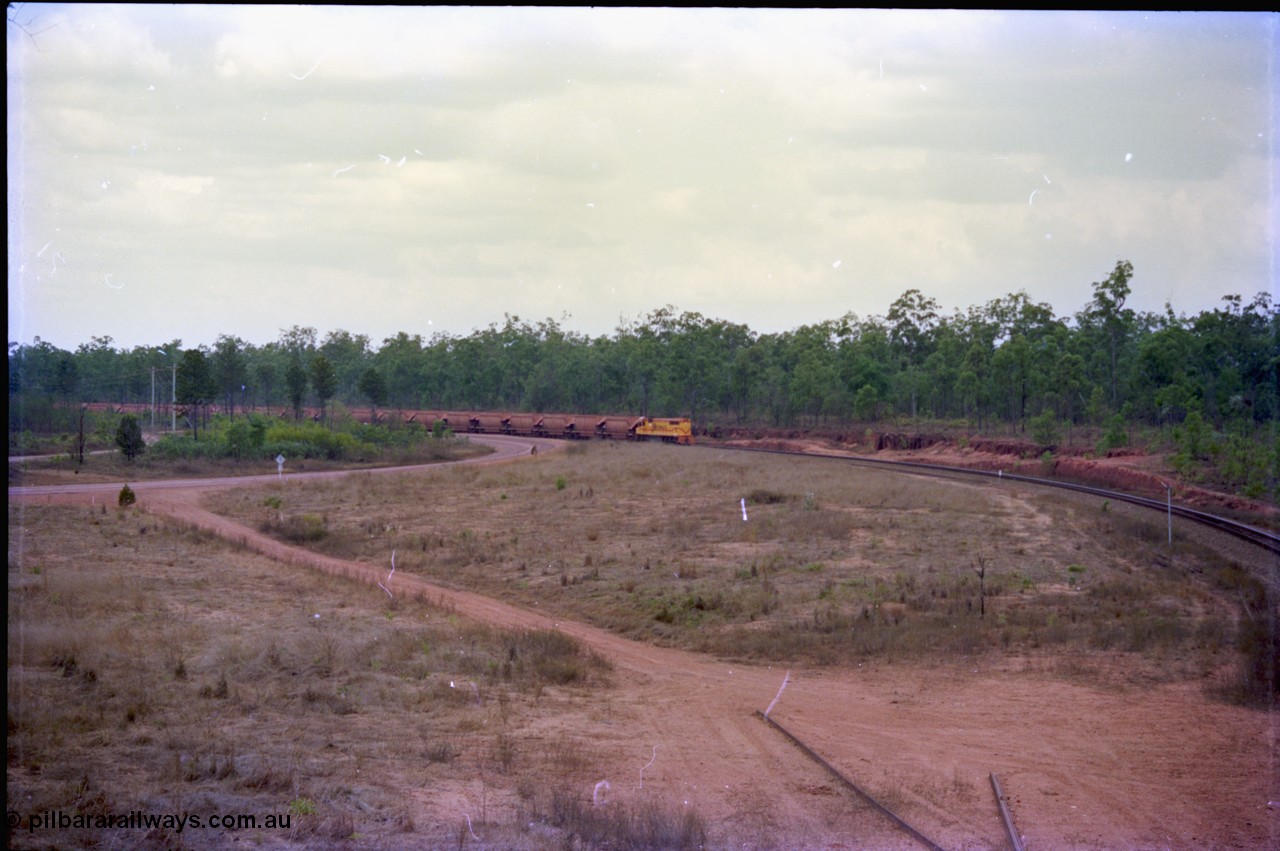 212-18
Weipa, a loaded train from Andoom around the curve as it approaches Lorim Point with thirty or so loaded waggons of bauxite.
