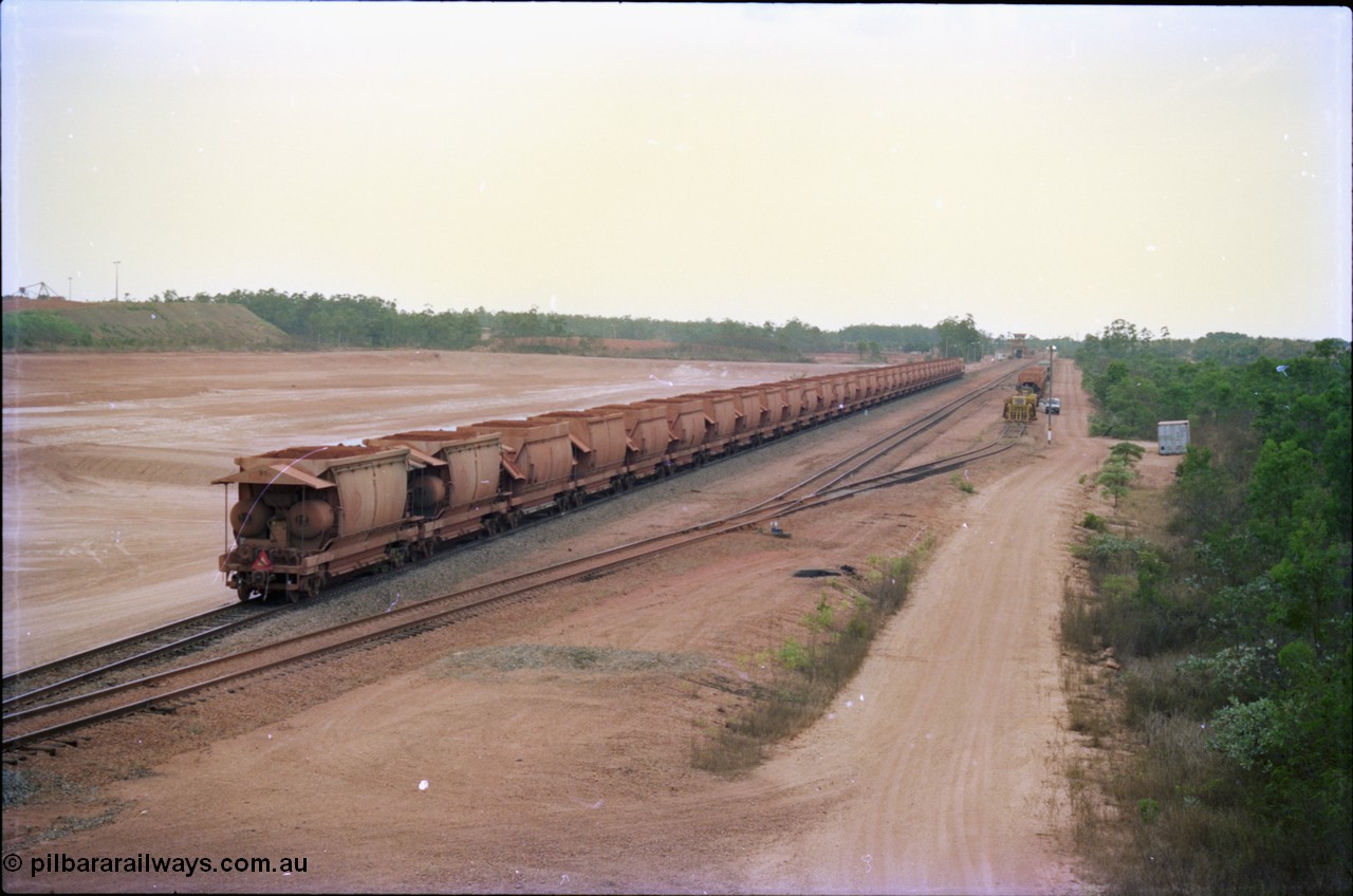 212-23
Weipa, a loaded train ex-Andoom Mine runs along the main with thirty two waggons at Lorim Point towards the dump station behind Comalco R 1001 Clyde Engineering built EMD model GT26C serial 72-752 originally numbered 1.001 and built in 1972. July 1995.
