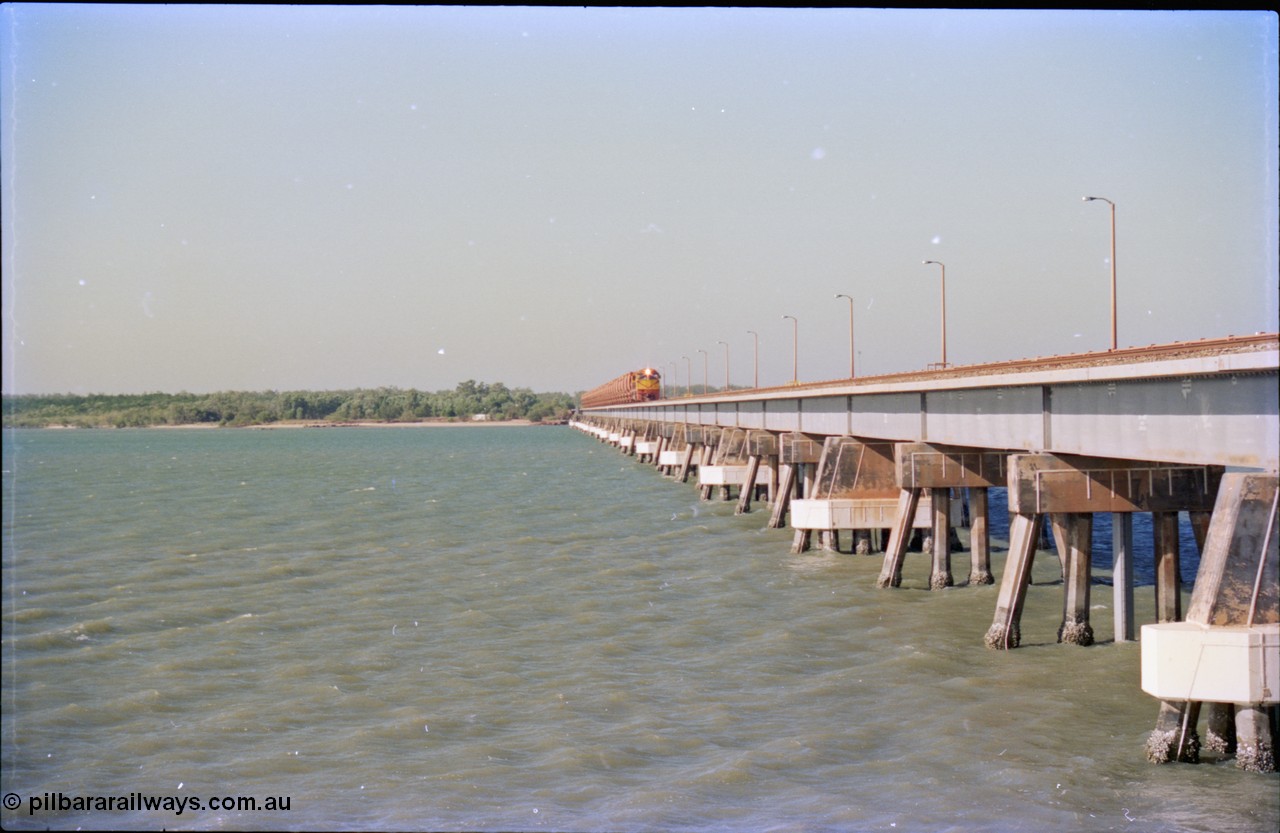 212-28
Weipa, Mission River road and rail bridge from the Andoom and rail side with an empty train headed by Comalco unit R 1004 purchased off BHP Iron Ore in 1994 is a Clyde Engineering built EMD model JT42C built in 1990 with serial 90-1277. July 1995.
Keywords: R1004;Clyde-Engineering-Kelso-NSW;EMD;JT26C;90-1277;Comalco;GML10;Cinderella;GML-class;
