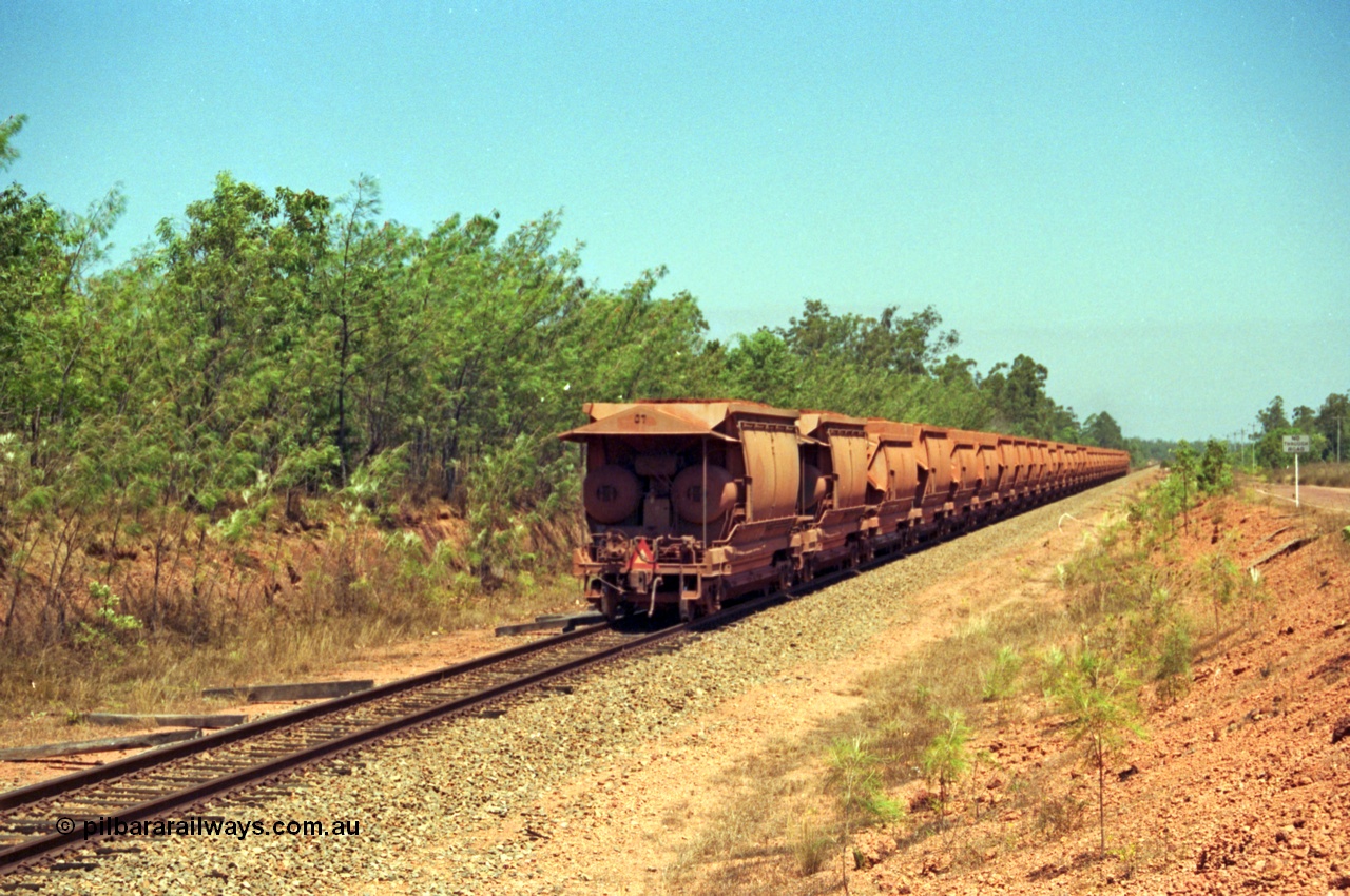 213-35
Weipa, trailing view of a loaded train from Andoom near Northern Avenue with Comalco R 1004 out of site leading thirty three loaded waggons of bauxite.
Keywords: R1004;Clyde-Engineering-Kelso-NSW;EMD;JT26C;90-1277;Comalco;GML10;Cinderella;GML-class;