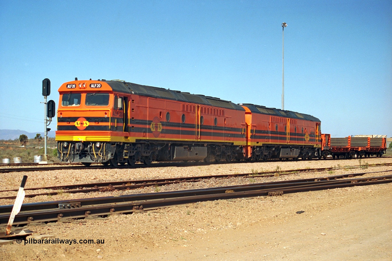 244-05
Port Augusta yard, a pair of ALF class units on the Darwin line construction shunt a rail transport waggon. ALF 20 and ALF 18 are both Morrison Knudsen rebuilds, model JT26C-2M serials 94-AN-020 and 94-AN-018.
Keywords: ALF-class;ALF18;ALF20;MKA;EMD;JT26C-2M;94-AN-018;94-AN-020;rebuild;AL-class;Clyde-Engineering;EMD;JT26C;
