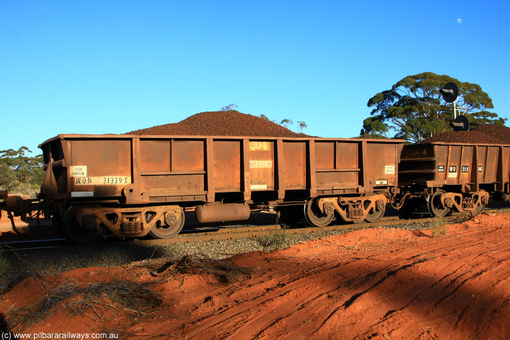 100731 02346
WOB type iron ore waggon WOB 31379 is one of a batch of twenty five built by Comeng WA between 1974 and 1975 and converted from Mt Newman high sided waggons by WAGR Midland Workshops with a capacity of 67 tons with fleet number 304 for Koolyanobbing iron ore operations, the WAGR and Comeng builders plates are visible in the waggon sill, on loaded train 6413 at Binduli Triangle, 31st July 2010.
Keywords: WOB-type;WOB31379;Comeng-WA;Mt-Newman-Mining;