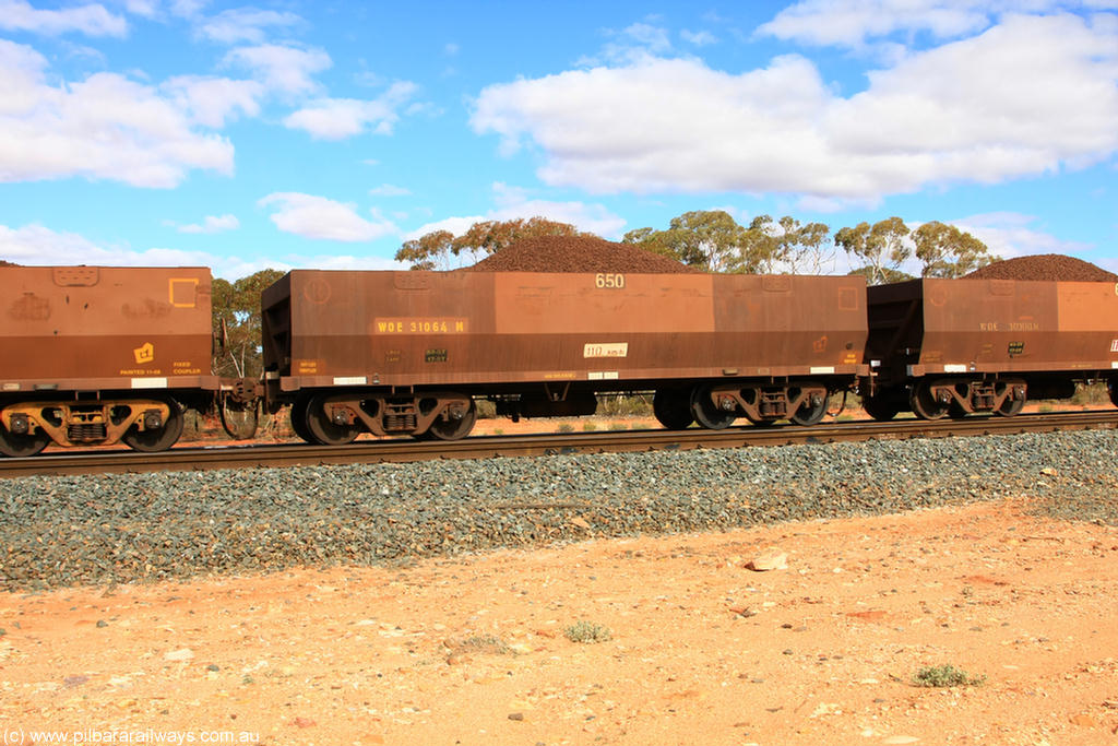 100731 02873
WOE type iron ore waggon WOE 31064 is one of a batch of one hundred and thirty built by Goninan WA between March and August 2001 with serial number 950092-054 and fleet number 650 for Koolyanobbing iron ore operations, on loaded train 7415 at Binduli Triangle, 31st July 2010.
Keywords: WOE-type;WOE31064;Goninan-WA;950092-054;