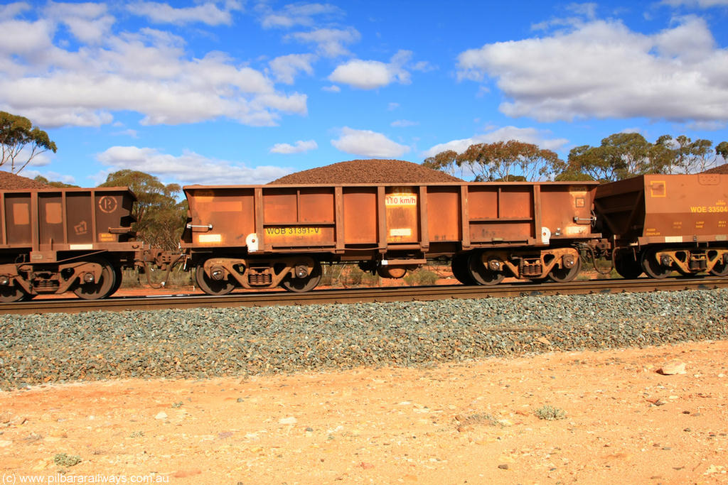 100731 02896
WOB type iron ore waggon WOB 31391 is one of a batch of twenty five built by Comeng WA between 1974 and 1975 and converted from Mt Newman high sided waggons by WAGR Midland Workshops with a capacity of 67 tons with fleet number 316 for Koolyanobbing iron ore operations. This waggon was also converted to a WSM type ballast hopper by re-fitting the cut down top section and having bottom discharge doors fitted, converted back to WOB in 1998, on loaded train 7415 at Binduli Triangle, 31st July 2010.
Keywords: WOB-type;WOB31391;Comeng-WA;WSM-type;Mt-Newman-Mining;