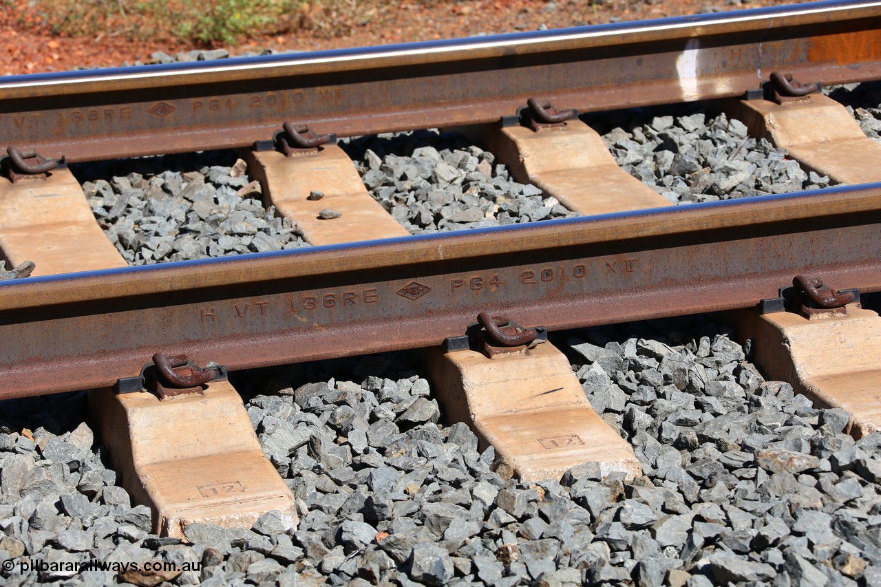 150505 7948
FMG Solomon Line track - rail detail, H VT 136 RE PG4 2010 XII, H for head hardened, VT for vacuum degassing, the diamond logo PZH indicates it is manufactured by Pangang Group Steel Vanadium & Titanium Co. Ltd, is 136 pounds per yard weight, RE meets AREMA (American Railway Engineering and Maintenance-of-Way Association) standards, PG4 indicates tensile strength of 1300 MPa, and a rolled date of 2010, December.
