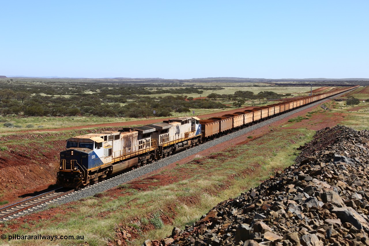 150505 7963
FMG Solomon Line, a pair of General Electric Dash 9-44CW locomotives 005 serial 58182 and 006 serial 58183 struggle upgrade with a loaded train at the 227 km bound for Port Hedland, the bank engines assisting in the rear can just be seen. Geodata: [url=https://goo.gl/maps/NjHo38Gc7kE2] -22.0189283 118.5861050 [/url].
Keywords: FMG-005;GE;Dash-9-44CW;58182;FMG-006;58183;
