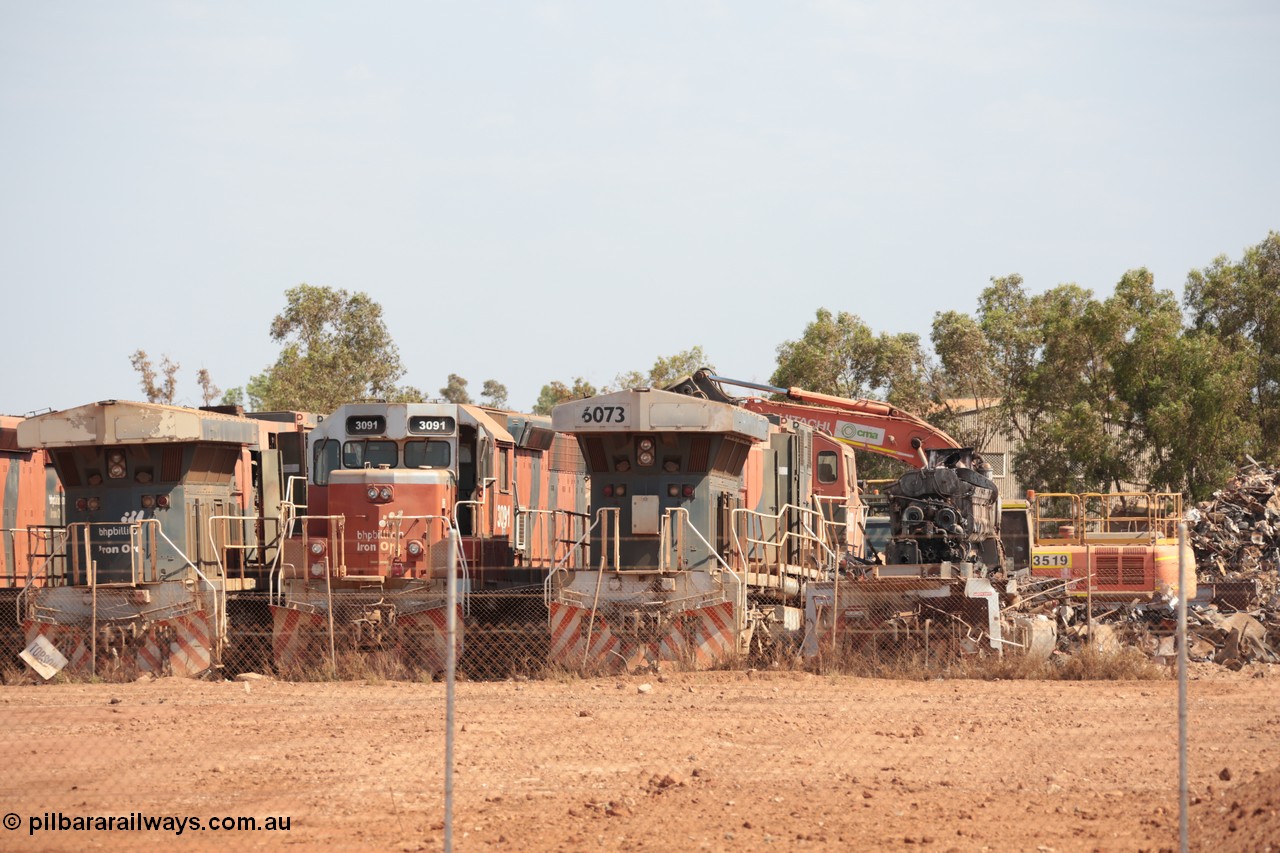141025 5821
Wedgefield, WA, view from the new bypass road looking into the rear of Sell and Parker's metal recycling yard with former BHP Billiton Iron Ore EMD SD40R and GE AC6000 model units lined up awaiting their fate, from left, AC6000 6075, SD40R 3091, AC6000 6073 and remains of another SD40R.
Keywords: S+P;6073;GE;AC6000;51065;EMD;SD40R;3091;31496/7861-6;