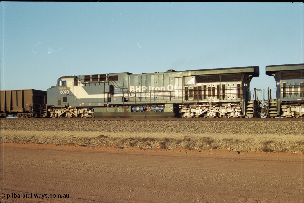 203-04
Bing Siding, BHP General Electric built AC6000 class leader 6070 'Port Hedland' serial 51062 in the passing track as second unit on a Yandi empty working. The size of the BHP AC6000 model radiator is clearly evident here.
Keywords: 6070;GE;AC6000;51062;