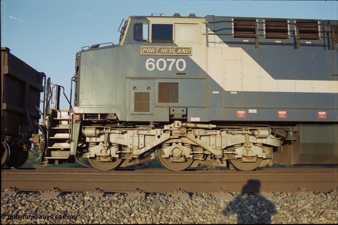 203-06
Bing Siding, BHP General Electric built AC6000 class leader 6070 'Port Hedland' serial 51062 in the passing track as second unit on a Yandi empty working. Cab side view with name board and steerable bogie.
Keywords: 6070;GE;AC6000;51062;