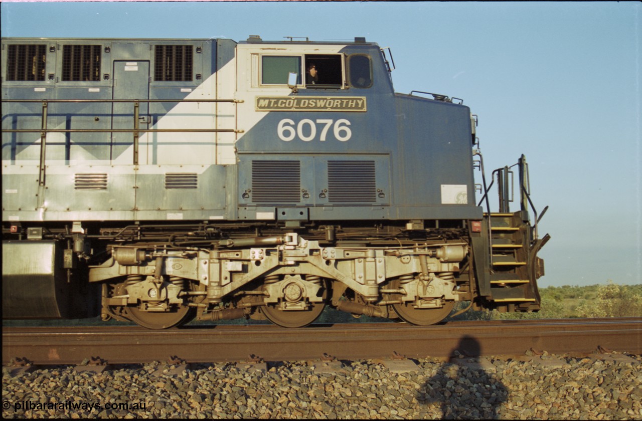 203-12
Bing Siding, BHP Iron Ore General Electric AC6000 model 6076 'Mt Goldsworthy' serial 51068 with an empty train. Cab side view with name board, steerable bogie and Driver Cosgrove at the controls.
Keywords: 6076;GE;AC6000;51068;