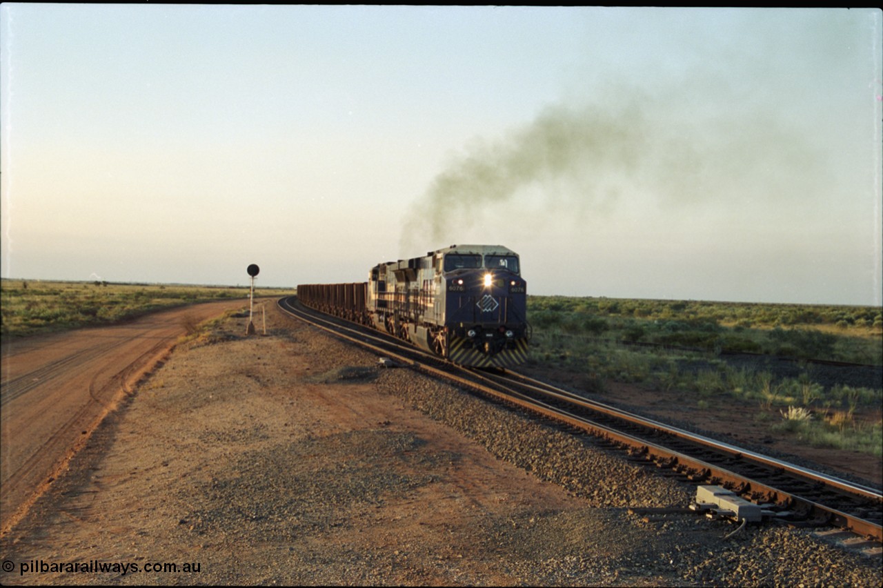 203-19
Bing Siding, with the empty clear, BHP General Electric AC6000 unit 6076 'Mt Goldsworthy' serial 51068 powers its' train out of the passing track at Bing South.
Keywords: 6076;GE;AC6000;51068;