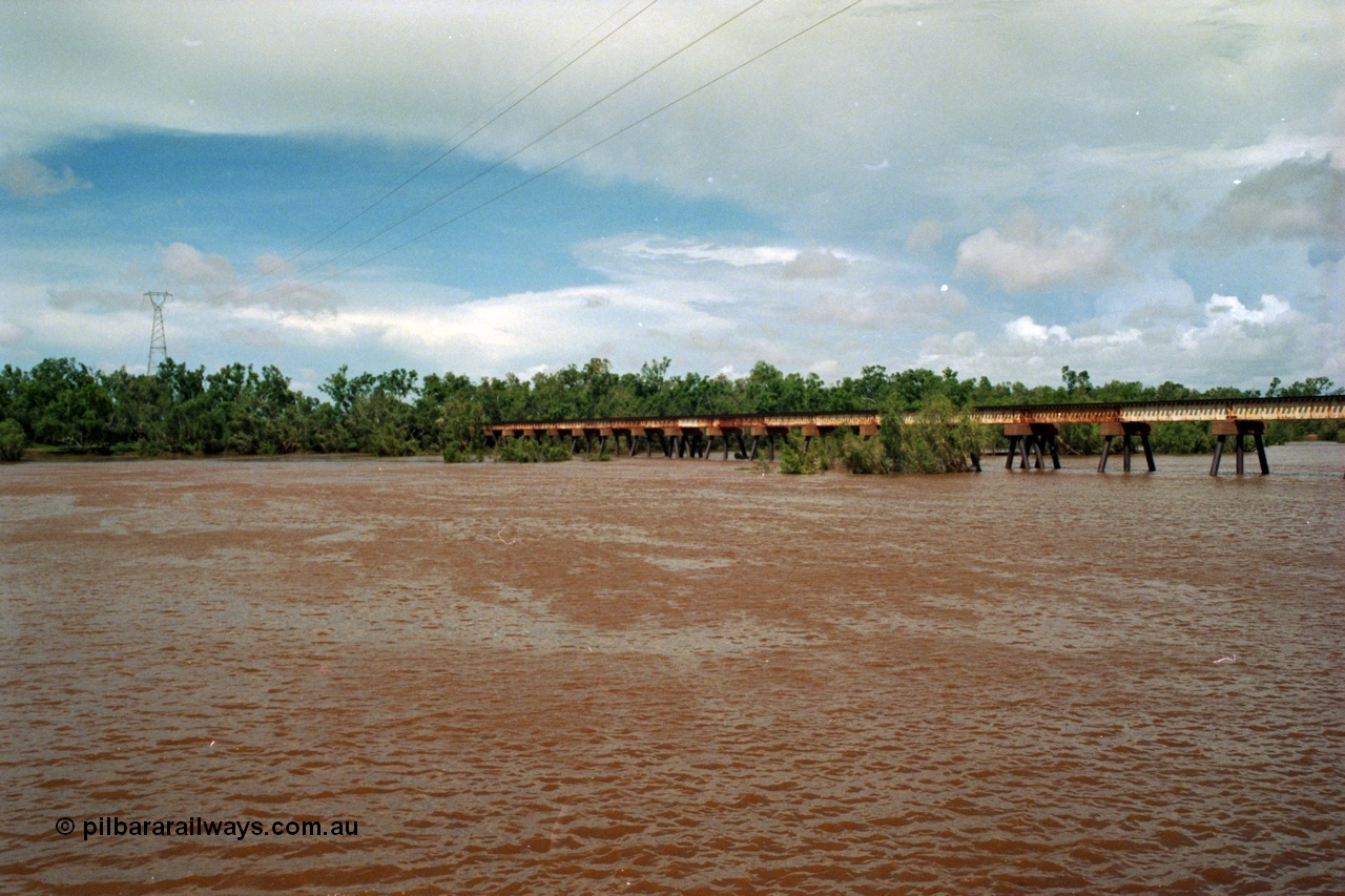 218-05
De Grey River Bridge, former road and rail, now only rail bridge for the Goldsworthy line, looking east, river is in flood, wide angle view.
