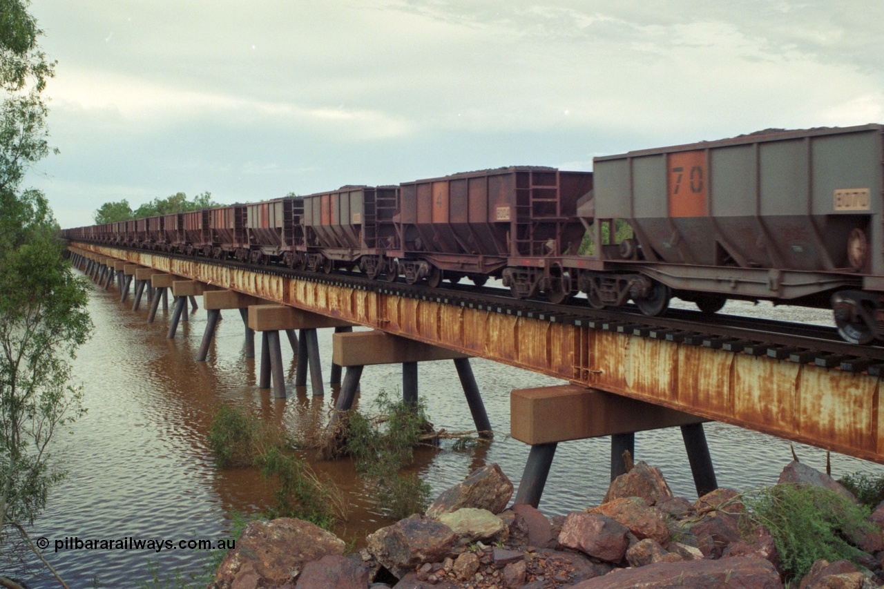 218-15
De Grey River Bridge, a loaded GML train with the original AE Goodwin designed and Tomlinson Steel Perth and Scotts of Ipswich built waggons.
