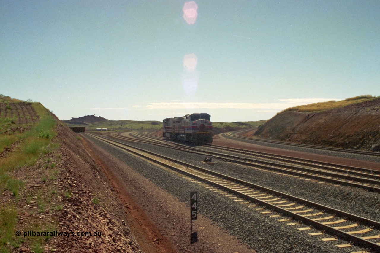 219-02
Yandicoogina or HIY as Hamersley Iron identify it, located 445 km from Parker Point yard in Dampier. Bank engine units General Electric Dash 9-44CW models 7089 serial 47768 and 7090 wait their next loaded train to push out, the tail of which is visible on the left with the mine stockpile in the background.
Keywords: 7089;GE;Dash-9-44CW;47768;