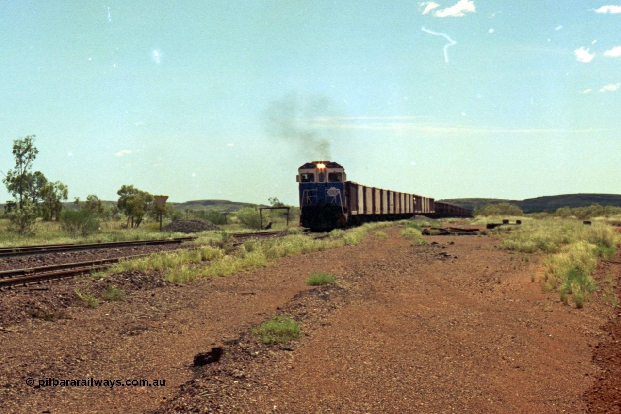 219-27
Goldsworthy Siding, C36-7M unit 5507 'Nimingarra' serial 4839-03 / 87-072, an original Mt Newman Mining ALCo C636 5461 to GE C36-7M rebuild carried out by Goninan, leads an empty train into the siding at Goldsworthy as the second driver watches the roll by under the shade of the shelter.
Keywords: 5507;Goninan;GE;C36-7M;4839-03/87-072;rebuild;AE-Goodwin;ALCo;C636;5461;G6035-2;