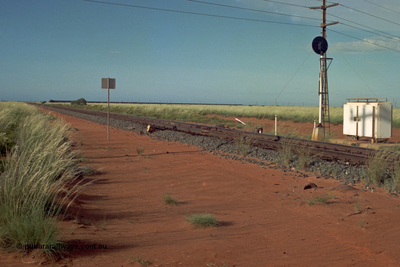 220-20
Goldsworthy Junction, looking north east along the Goldsworthy line as a loaded train ex Yarrie mine approaches rounding the curve, the grease pot for the curve behind the photographer is visible.

