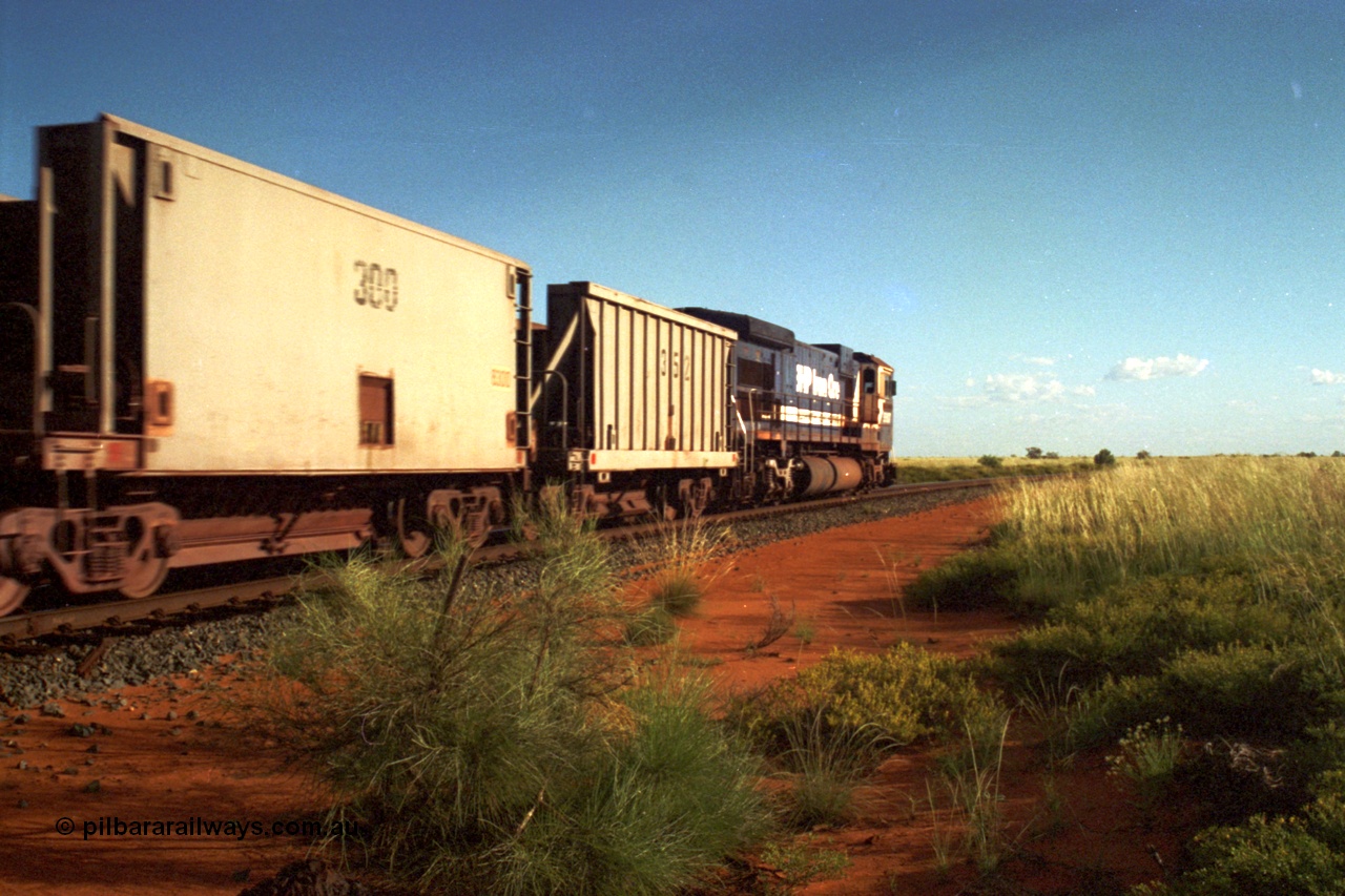 220-25
Goldsworthy Junction, a loaded train from Yarrie mine lead by BHP Dash 7 unit 5507 'Nimingarra' serial 4839-03 / 87-072 a Goninan WA ALCo rebuild C36-7M model and one each of the second-hand waggons purchased from Phelps Dodge Copper Mine, the ribbed unit 352 is a Portec USA build while the smooth sided 300 waggon is a Gunderson USA build.
