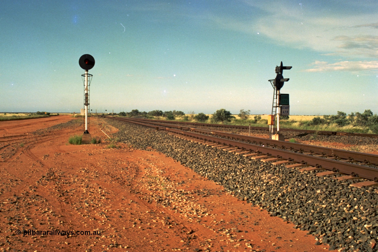 220-26
Goldsworthy Junction, an empty train on the Newman line approaches having departed Nelson Point. The line merging in from the right is the Goldsworthy line to Yarrie and Nimingarra, which can then be made out diverging to the left just after the interlocking room in front of the train.
