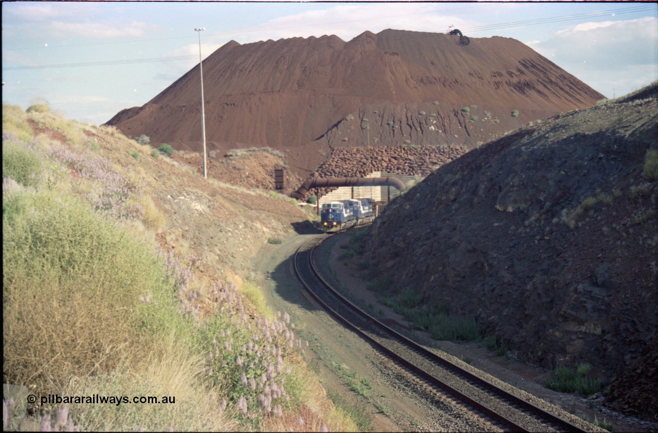 221-27
Yandi One mine loadout balloon loop, a pair of General Electric AC6000 units lead a train being loaded around the balloon, overview of the stockpile with stacker fill the hole from loading.
Keywords: GE;AC6000;51062-9;