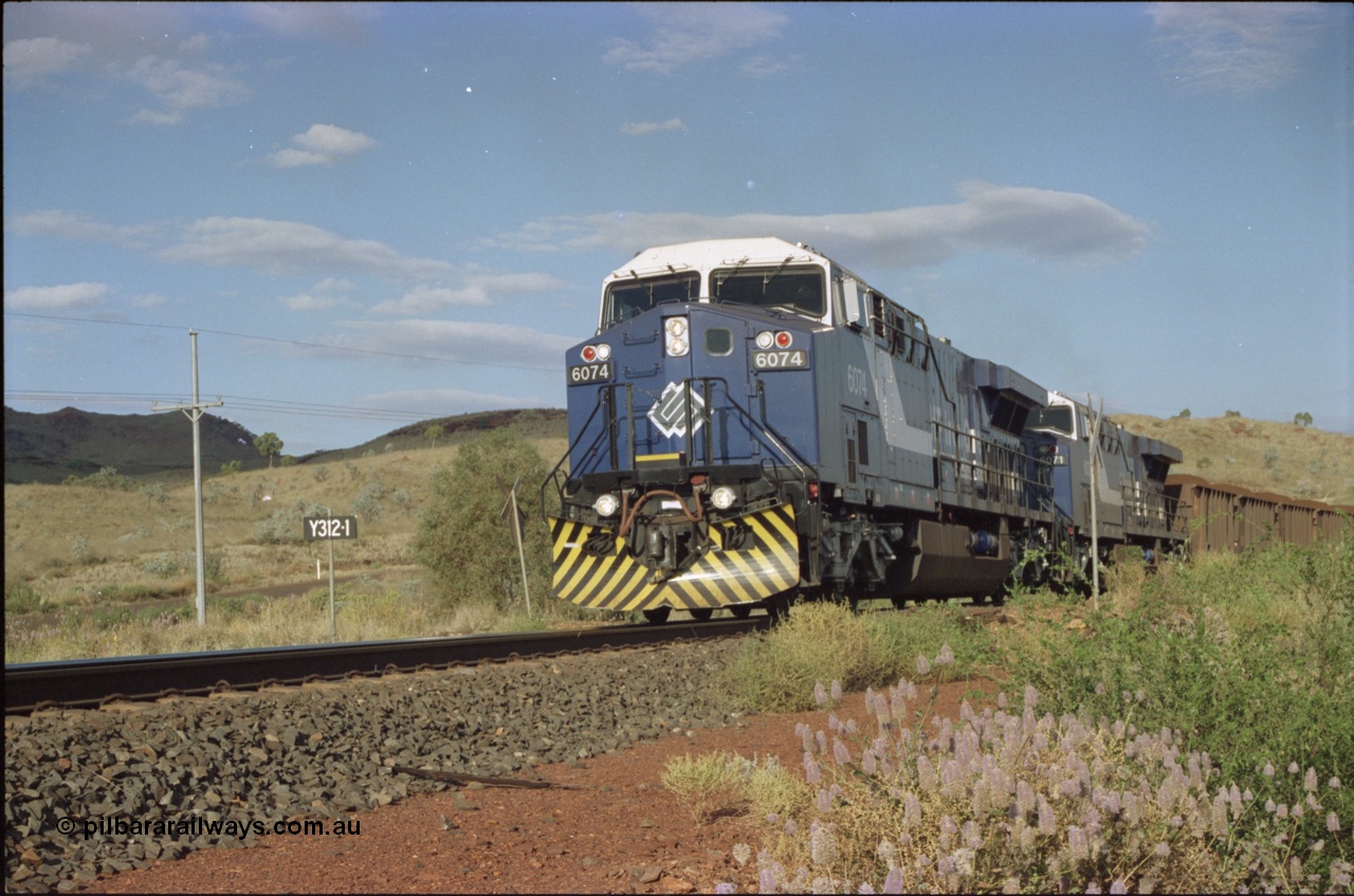 221-31
Yandi One mine loadout balloon loop, near new General Electric AC6000 unit 6074 serial 51066 leads sister unit 6071 serial 51063 at the Y312.1 km crossing while controlling a train being loaded.
Keywords: 6074;GE;AC6000;51066;