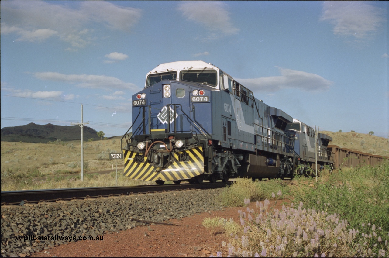 221-32
Yandi One mine loadout balloon loop, near new General Electric AC6000 unit 6074 serial 51066 leads sister unit 6071 serial 51063 at the Y312.1 km crossing while controlling a train being loaded.
Keywords: 6074;GE;AC6000;51066;