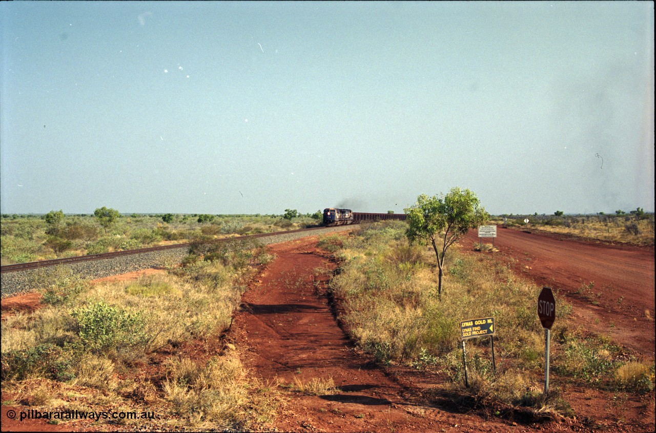 222-01
At the 105.7 km grade crossing near Gillam Siding, a loaded Yandi train approaches behind two General Electric AC6000 units built by GE at their Erie plant. This road was also the original road into Lynas Find Gold Project, back in the day. [url=https://goo.gl/maps/7emwhQdnBN32]GeoData[/url].
