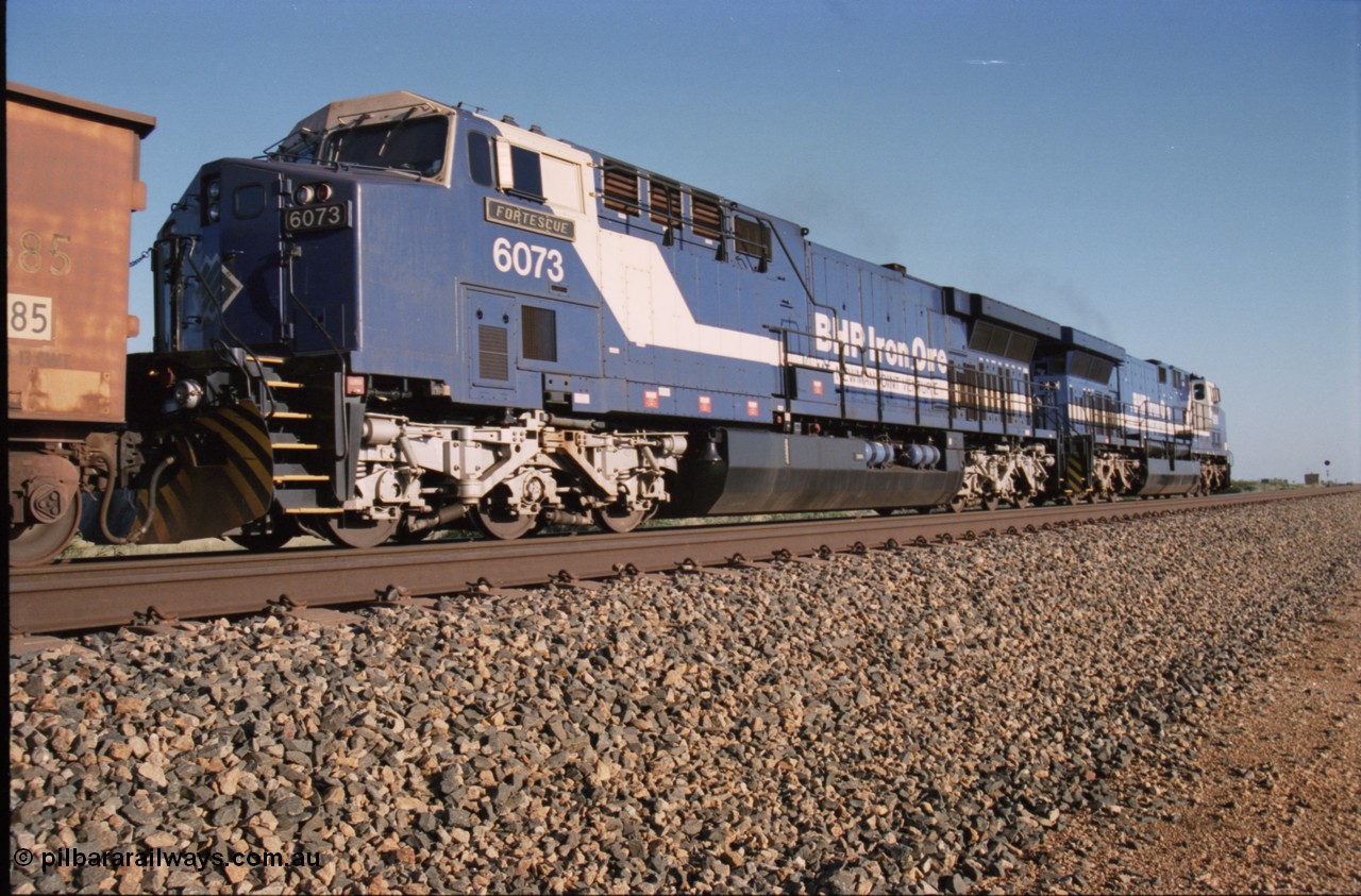 224-11
Bing siding, 6073 'Fortescue' serial 51065 a General Electric AC6000 built by GE at Erie awaits the road to depart south, shows new nameplate, steerable bogie and taper in cab side, second unit behind sister loco 6076. [url=https://goo.gl/maps/KQrczNpVhAH2]GeoData[/url].
Keywords: 6073;GE;AC6000;51065;