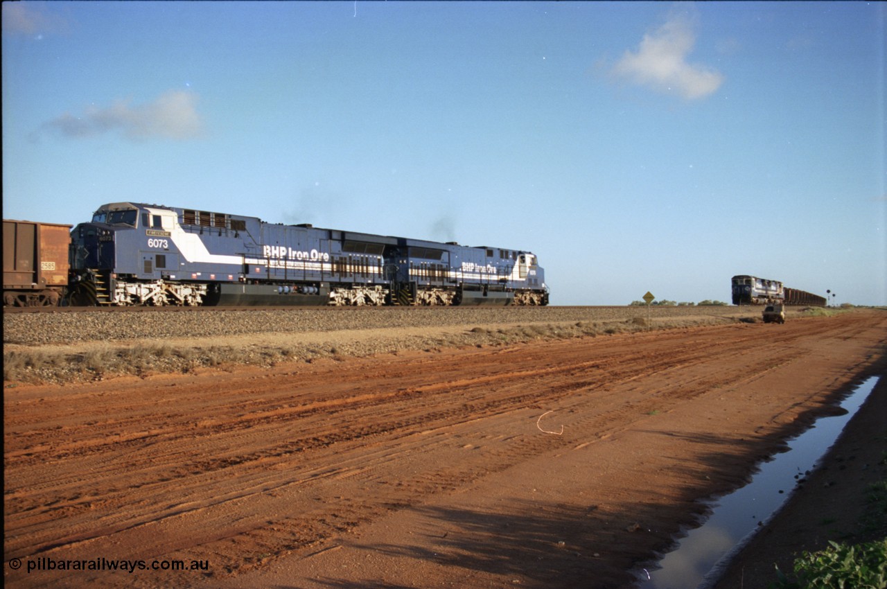224-22
Bing siding, the afternoon empty to Yandi was a staple of the AC6000 units when delivered, operating the train as a pair, 112 waggons, AC6000 and 112 waggons. 6076 'Mt Goldsworthy' serial 51068 a General Electric AC6000 built by GE at Erie awaits the road to depart south with sister unit 6073 as a loaded behind two CM40-8M units rolls through on the mainline. [url=https://goo.gl/maps/KQrczNpVhAH2]GeoData[/url].
Keywords: 6073;GE;AC6000;51065;