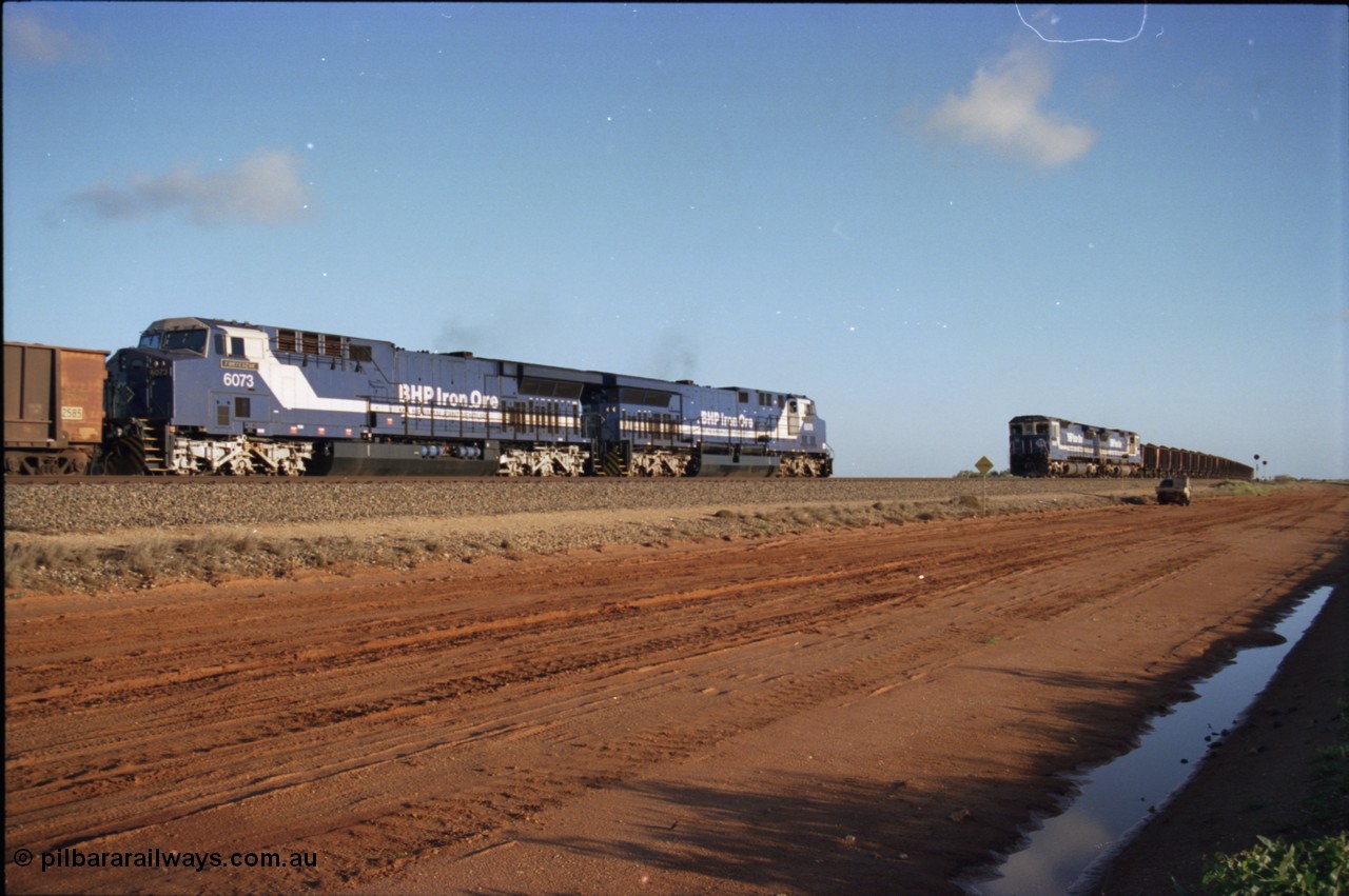 224-23
Bing siding, the afternoon empty to Yandi was a staple of the AC6000 units when delivered, operating the train as a pair, 112 waggons, AC6000 and 112 waggons. 6076 'Mt Goldsworthy' serial 51068 a General Electric AC6000 built by GE at Erie awaits the road to depart south with sister unit 6073 as a loaded behind two CM40-8M units rolls through on the mainline. [url=https://goo.gl/maps/KQrczNpVhAH2]GeoData[/url].
Keywords: 6073;GE;AC6000;51065;