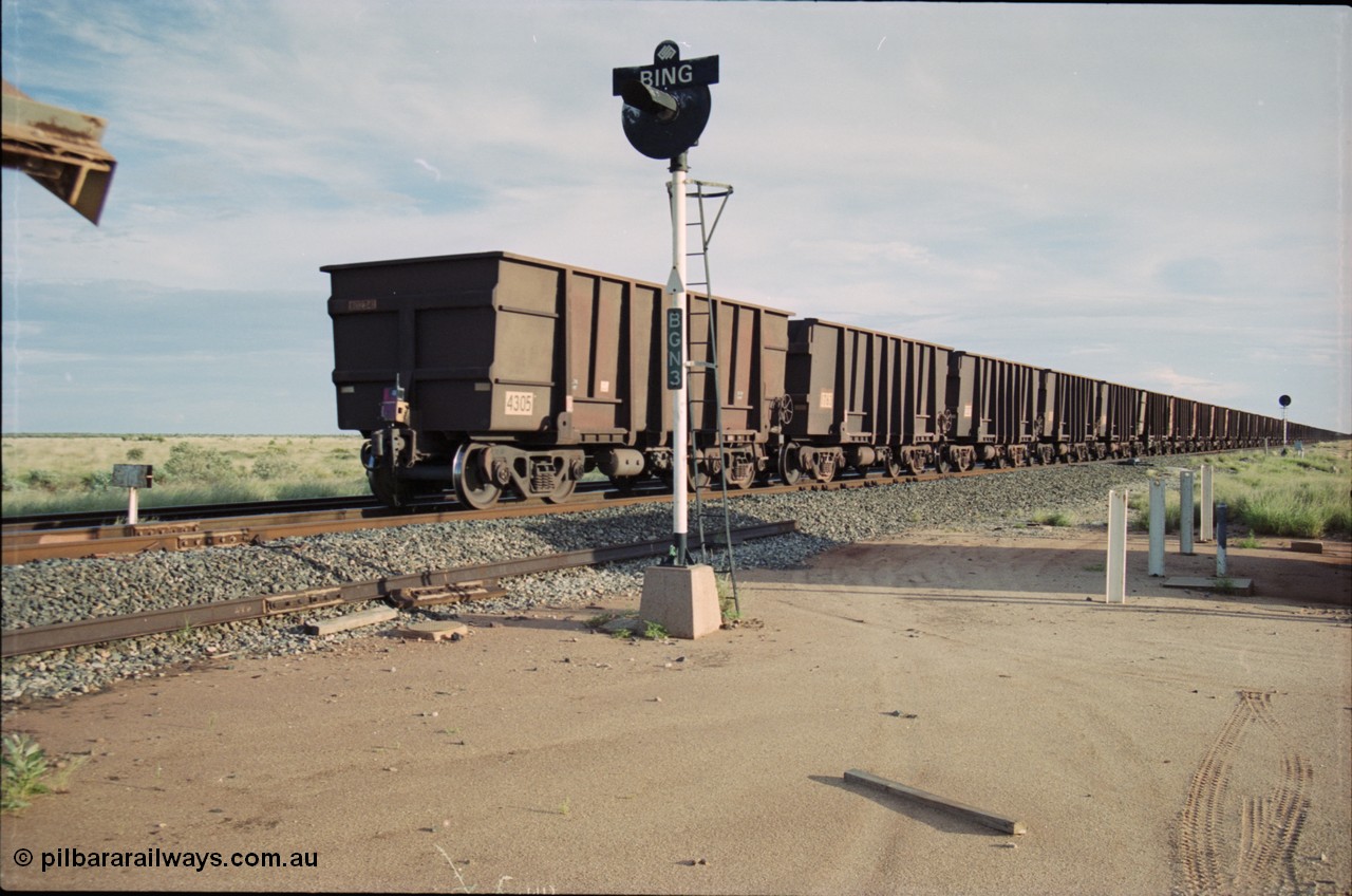 225-09
Bing siding, signal post BGN 3 stand sentinel as the end of the afternoon Yandi train is seen heading south with last waggon 4305, one of 126 such waggons constructed during 1997 out of 3CR12 stainless steel in an effort to eliminate painting and to reduce wear on the waggon body. This design was designated HC7081. [url=https://goo.gl/maps/r3bVfZz8aJS2]GeoData[/url].
Keywords: 4305;United-Goninan-WA;3CR12;HC7081;