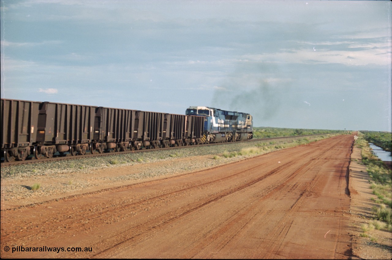 225-22
At the 24.1 km grade crossing on the BHP Newman line, the afternoon departure for Yandi mine heads south behind the standard double General Electric AC6000 units with GE Erie built 6075 serial 51067 second unit to lead sister unit 6074 with another AC6000 unit mid-train. This was before the units were named. [url=https://goo.gl/maps/qGkyfiuy6212]GeoData[/url].
