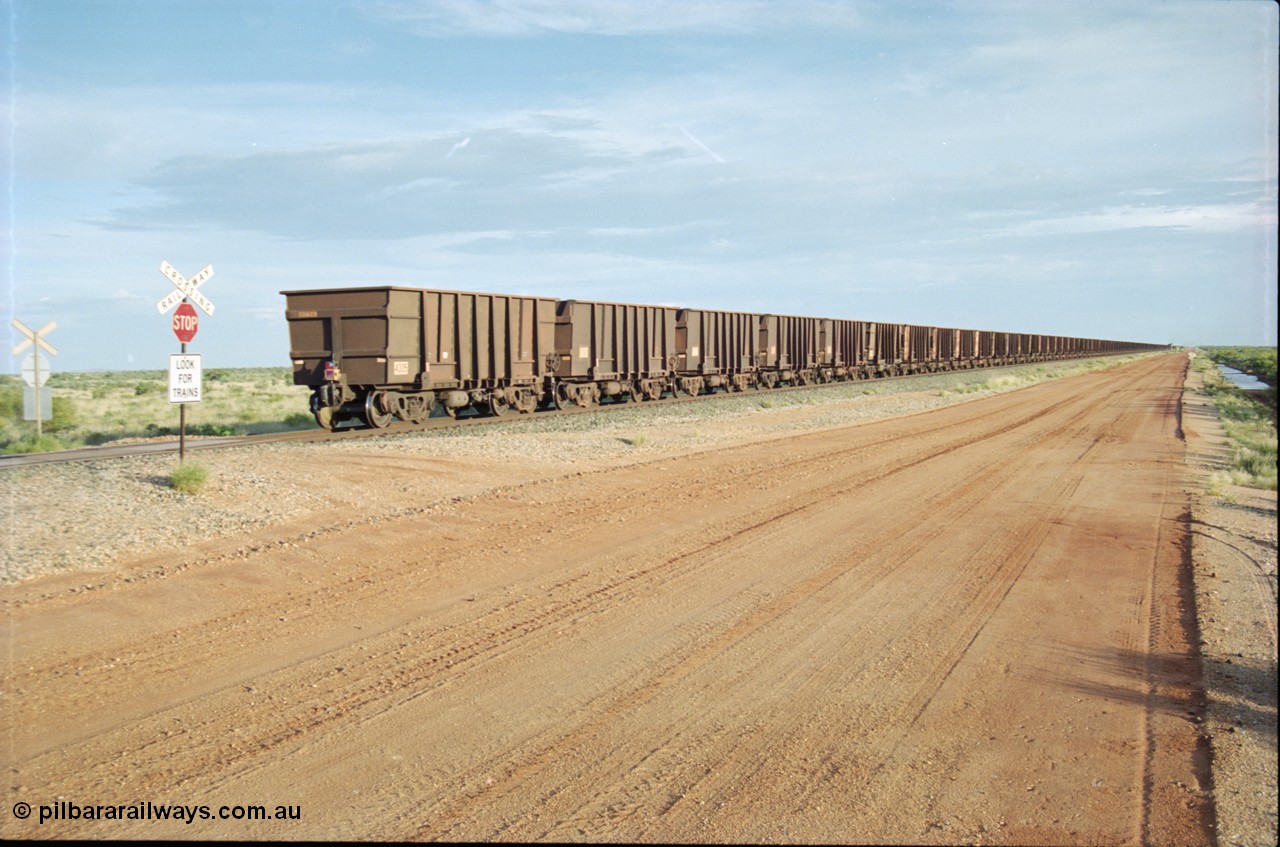 225-25
At the 24.1 km grade crossing on the BHP Newman line the end of the afternoon Yandi train is seen heading south with last waggon 4305, one of 126 such waggons constructed during 1997 out of 3CR12 stainless steel in an effort to eliminate painting and to reduce wear on the waggon body. This design was designated HC7081. [url=https://goo.gl/maps/qGkyfiuy6212]GeoData[/url].
Keywords: 4305;United-Goninan-WA;3CR12;HC7081;