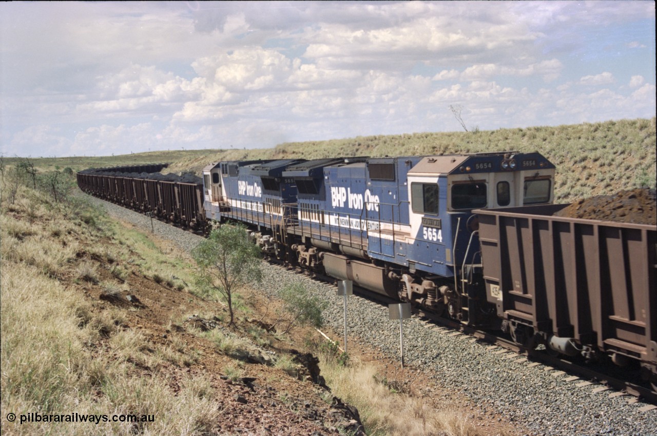 226-36
Shaw siding 219 km, 5654 'Kashima' serial 8412-11 / 93-145 is the trail or slave remote on the mid-train pair of units, note the large flat fuel tank indicating this unit was a Comeng NSW built ALCo before rebuild. [url=https://goo.gl/maps/JLjSYskHScU2]GeoData[/url].
Keywords: 5654;Goninan;GE;CM40-8M;8412-11/93-145;rebuild;Comeng-NSW;ALCo;M636C;5493;C6084-9;