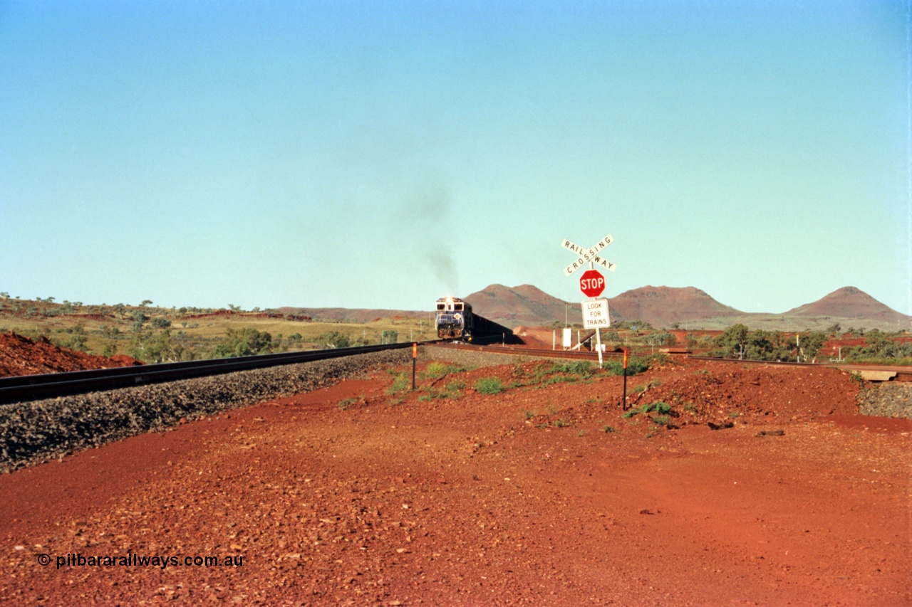 229-00
Yandi Two balloon switch looking east with the Three Sisters forming the background. Empty BHP train heading for the balloon loop for loading, grade crossing is the YT 311.5 km. [url=https://goo.gl/maps/DcycDGojcBt]GeoData[/url].
