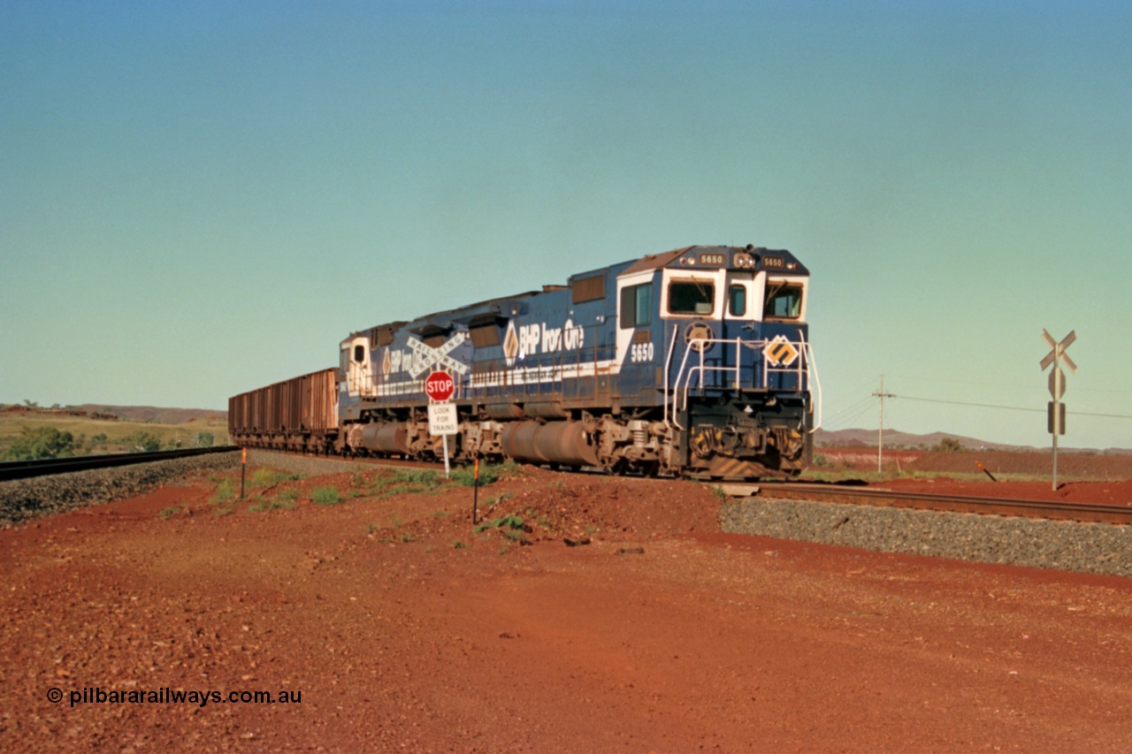 229-03
Yandi Two balloon switch looking east with an empty BHP train heading for the loadout behind a pair of Goninan rebuild CM40-8M GE units with 5650 'Yawata' serial 8412-07 / 93-141 leading sister unit 5642, grade crossing is the YT 311.5 km. [url=https://goo.gl/maps/DcycDGojcBt]GeoData[/url].
Keywords: 5650;Goninan;GE;CM40-8M;8412-07/93-141;rebuild;AE-Goodwin;ALCo;M636C;5481;G6061-2;