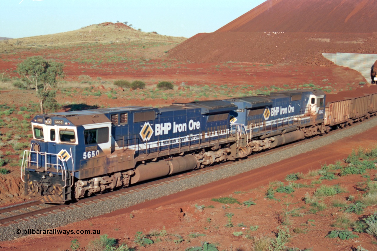 229-27
Yandi Two loadout exit side, Goninan rebuild CM40-8M GE units 5650 'Yawata' serial 8412-07 / 93-141 and sister unit 5642 drag a loading train at 1.2 km/h, both units carry the BHP Iron Ore teal and marigold livery for the logo. [url=https://goo.gl/maps/KQ3dQNrTwd42]GeoData[/url].
Keywords: 5650;Goninan;GE;CM40-8M;8412-07/93-141;rebuild;AE-Goodwin;ALCo;M636C;5481;G6061-2;